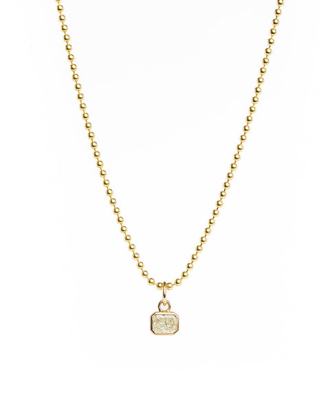Gold necklace with a small pendant on a white background