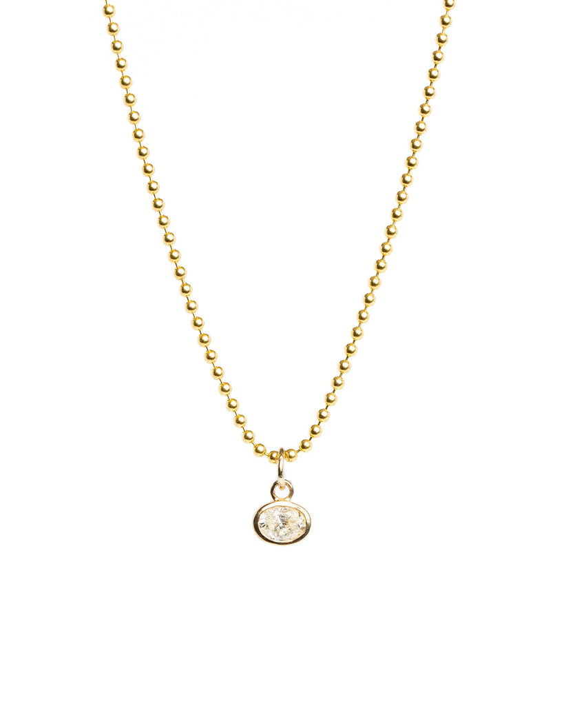 Gold necklace with a small round pendant on a white background
