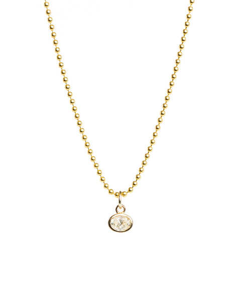 Gold necklace with a small round pendant on a white background