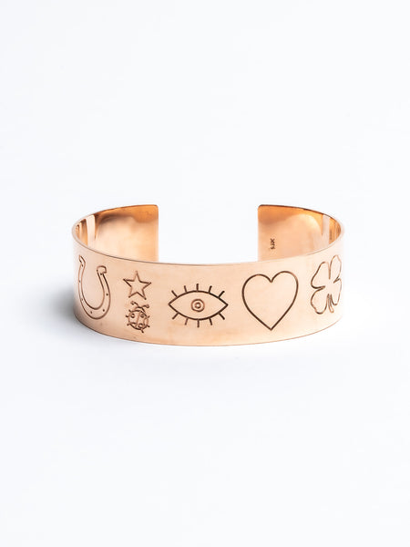 Genevieve Lau jewelry.  Wide gold cuff with lucky symbols engraved on it. Shown in rose gold.  